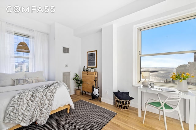 bedroom featuring baseboards, visible vents, and light wood-style floors