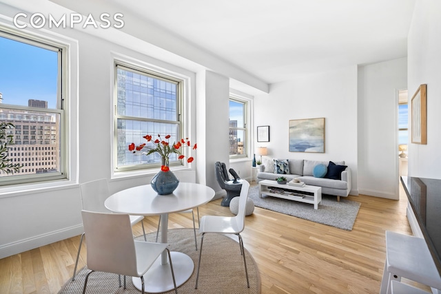 dining room featuring light wood-style flooring and baseboards