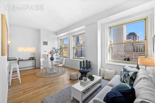 living area featuring a view of city, wood finished floors, and baseboards