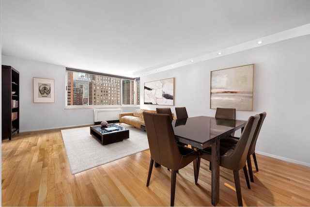 dining area featuring baseboards, light wood-type flooring, and recessed lighting