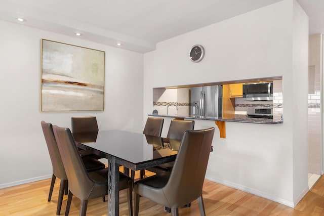 dining space with light wood-style floors, baseboards, and recessed lighting