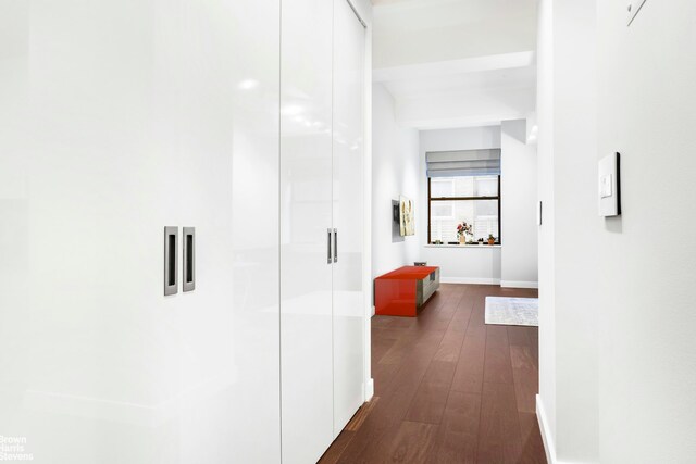 hall featuring dark wood-style floors and baseboards