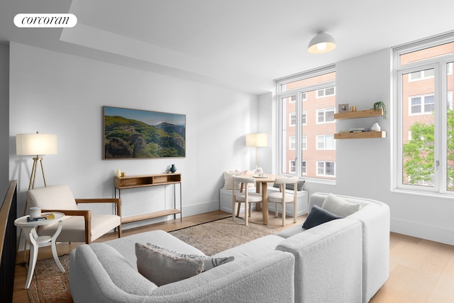 living room with visible vents, baseboards, and wood finished floors