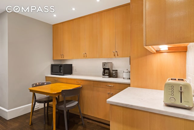 kitchen with black microwave, recessed lighting, baseboards, backsplash, and dark wood-style floors