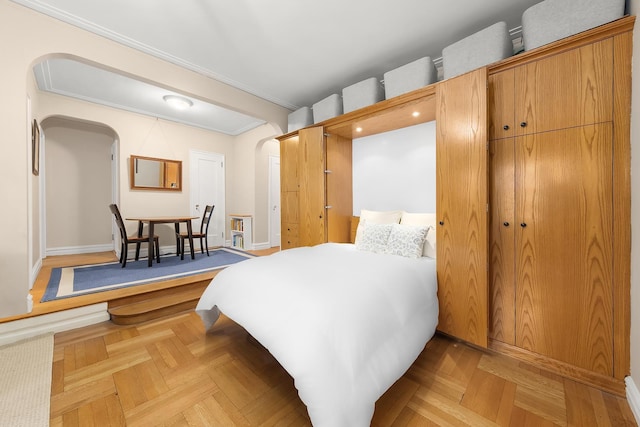 161 E 88th St Unit 6C, New York City, NY 10128 - bedroom featuring arched walkways, ornamental molding, and baseboards
