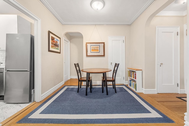161 E 88th St Unit 6C, New York City, NY 10128 - dining space featuring arched walkways, wood finished floors, baseboards, and ornamental molding