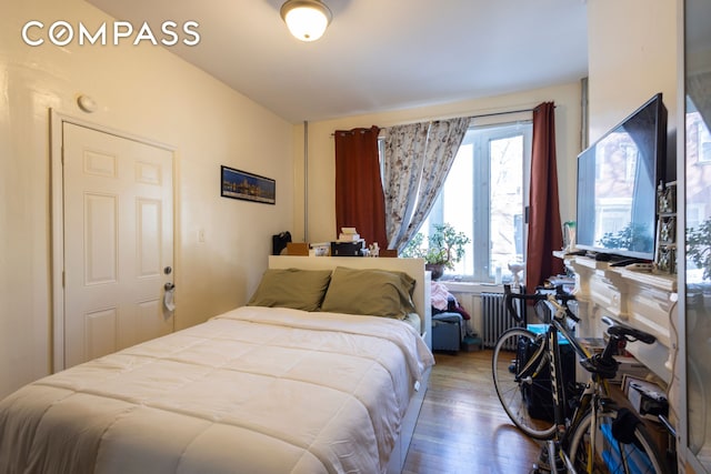 bedroom featuring radiator heating unit and dark wood-style flooring