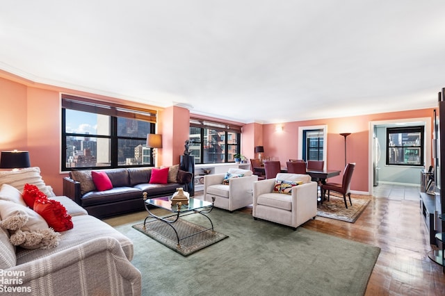 living area with plenty of natural light, baseboards, and wood finished floors