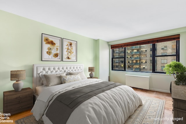 305 E 40th St Unit 17Jk, New York City, NY 10017 - bedroom featuring radiator and light wood finished floors