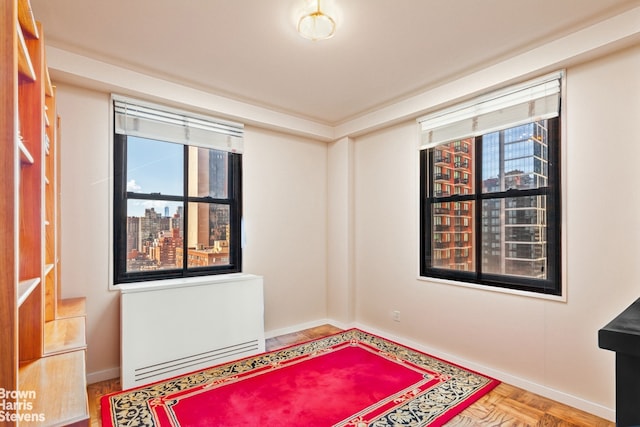 305 E 40th St Unit 17Jk, New York City, NY 10017 - unfurnished room with plenty of natural light, radiator, a view of city, and baseboards