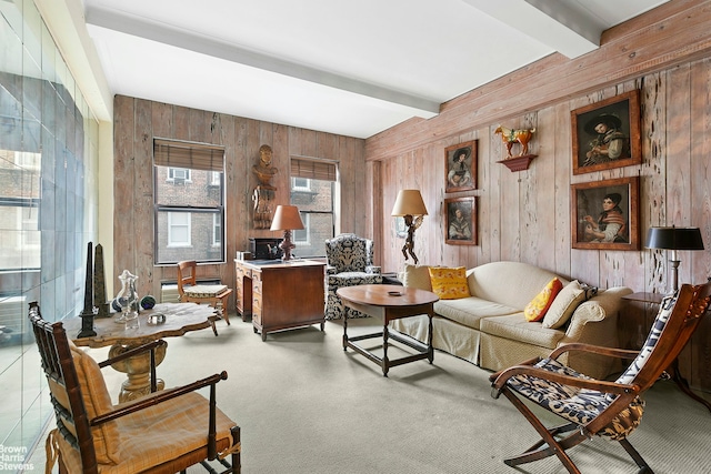 carpeted living room featuring beam ceiling and wood walls