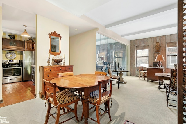 dining area with beam ceiling and light carpet