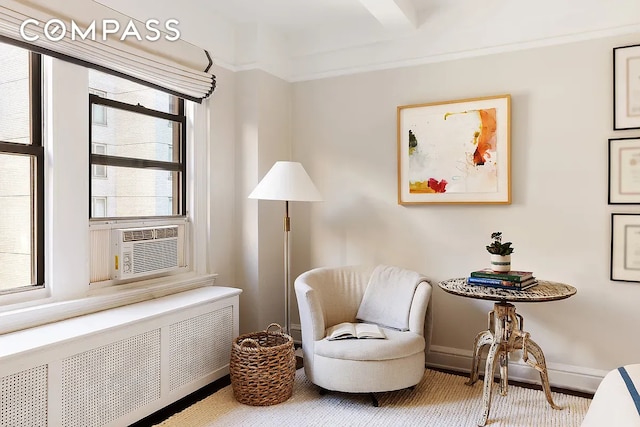 sitting room with radiator, cooling unit, and baseboards