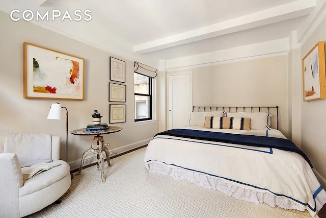 bedroom featuring beamed ceiling and baseboards