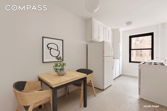 kitchen with baseboards, white cabinetry, and white appliances