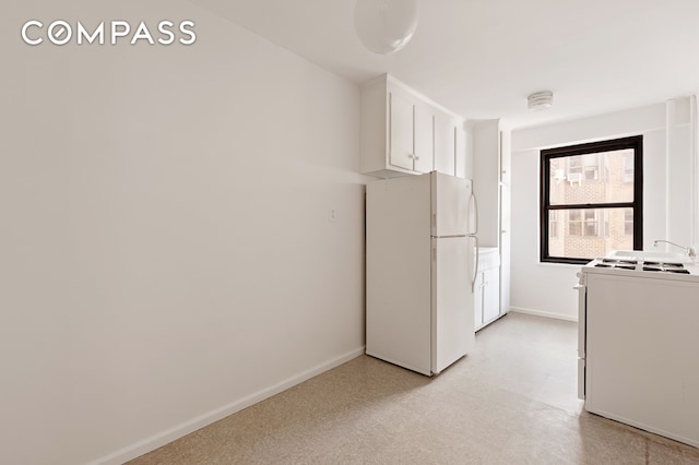 kitchen featuring light floors, white cabinets, baseboards, and white appliances