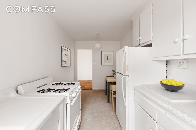 kitchen featuring white cabinets, light countertops, baseboards, light carpet, and white appliances