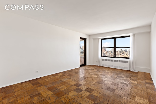 spare room featuring baseboards and radiator