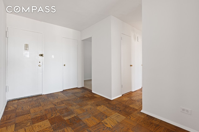 unfurnished room with baseboards