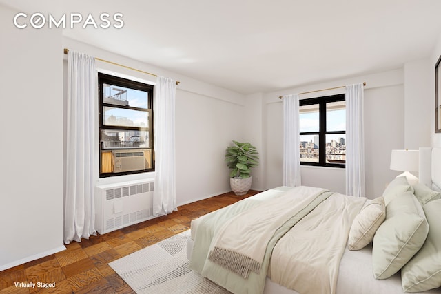 bedroom with multiple windows, cooling unit, and radiator