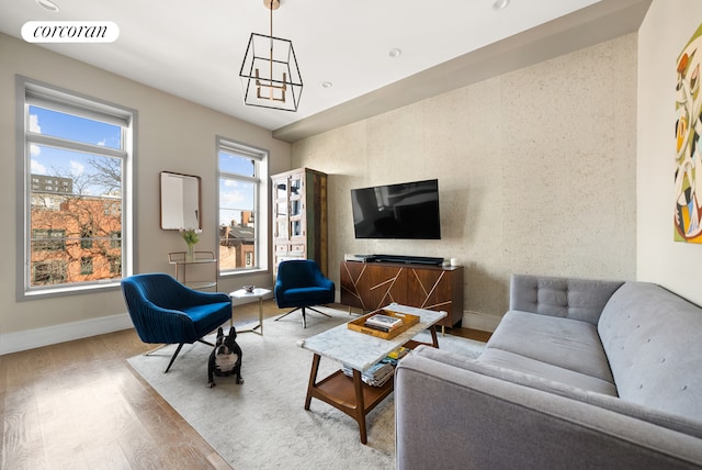 living area featuring baseboards, visible vents, and wood finished floors