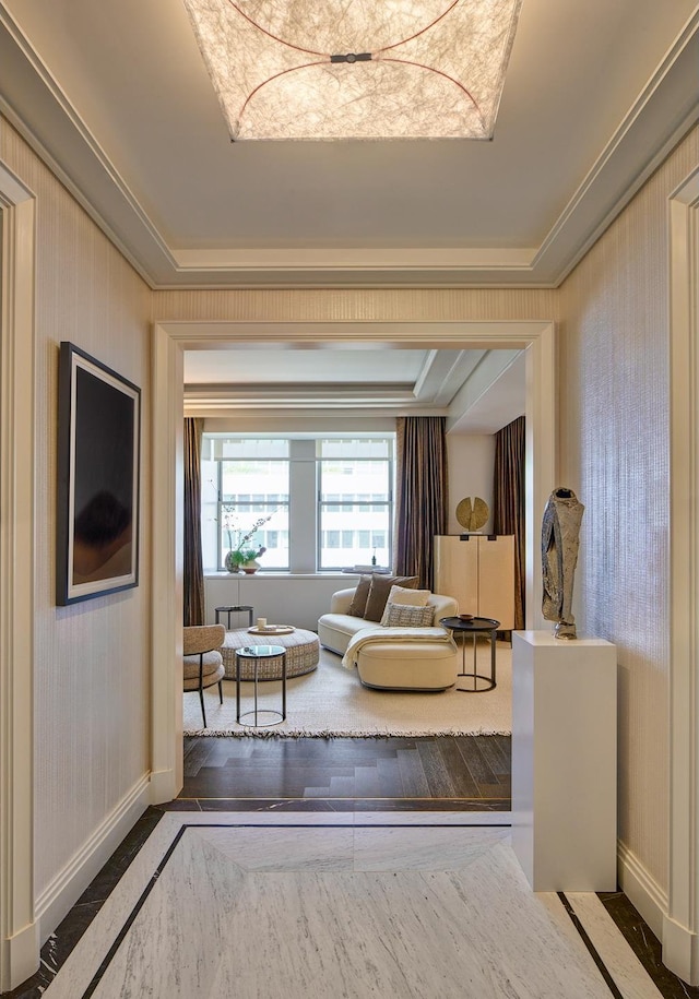 living room with wood finished floors, wallpapered walls, baseboards, and ornamental molding