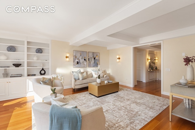 living area featuring built in shelves, light wood-type flooring, and baseboards