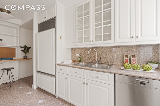 kitchen featuring a sink, granite finish floor, white cabinets, and stainless steel dishwasher