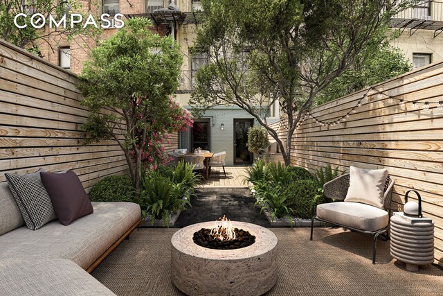 view of patio / terrace with a fenced backyard, an outdoor structure, and a fire pit