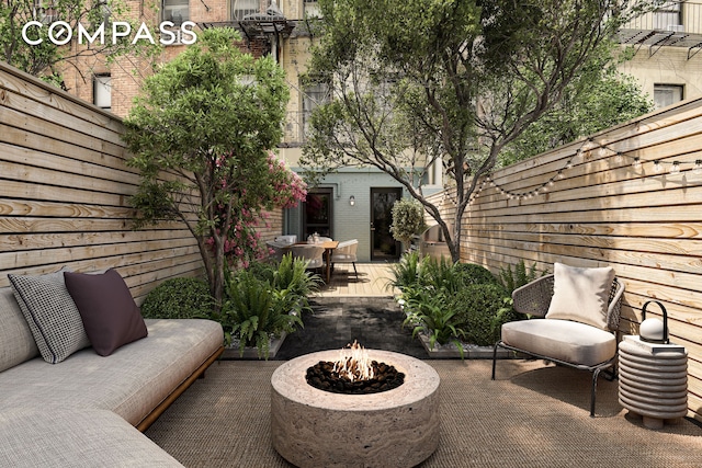 view of patio / terrace with an outdoor structure, a fenced backyard, and an outdoor fire pit