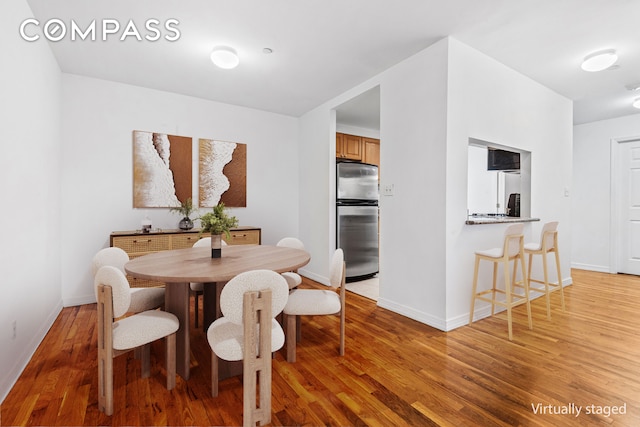 dining room featuring light wood-style floors and baseboards