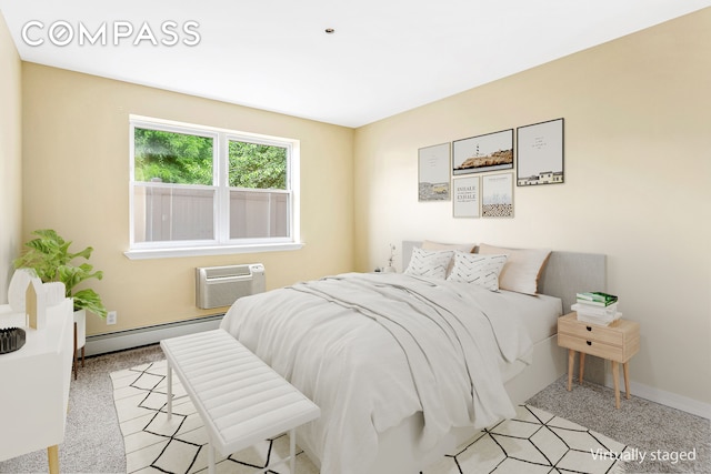 bedroom with baseboard heating, a wall unit AC, and baseboards