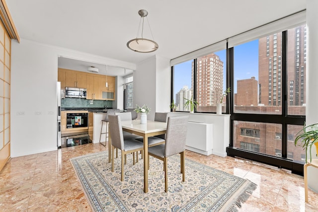 dining space featuring a view of city and crown molding