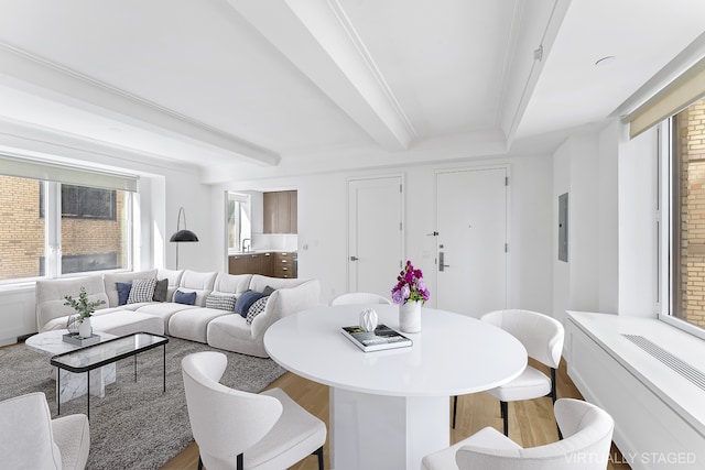 dining room featuring electric panel, beamed ceiling, and wood finished floors