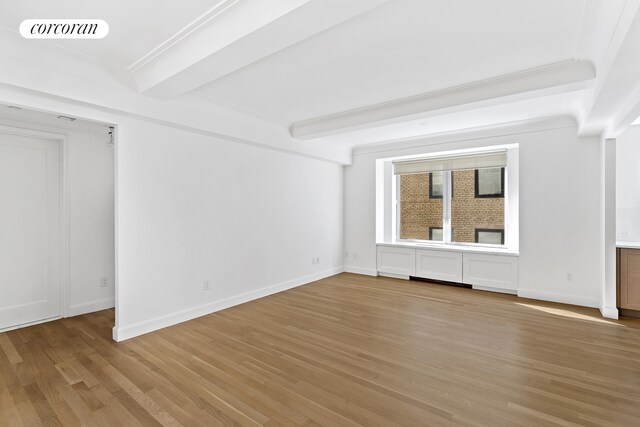 unfurnished room featuring visible vents, beamed ceiling, and light wood-style flooring