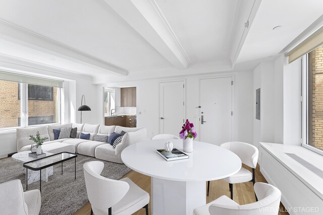 dining room with electric panel, beamed ceiling, and wood finished floors