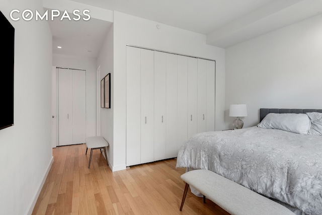 bedroom featuring light wood-style floors, baseboards, and a closet