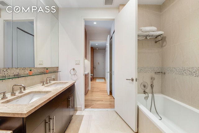 full bathroom with tasteful backsplash, a sink, shower / tub combination, and tile patterned floors