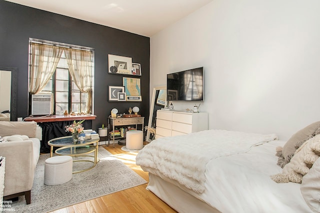 bedroom featuring cooling unit and wood finished floors