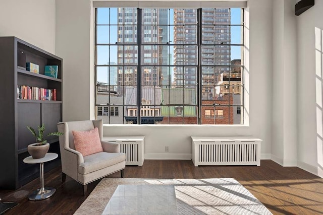 sitting room with radiator, baseboards, and wood finished floors