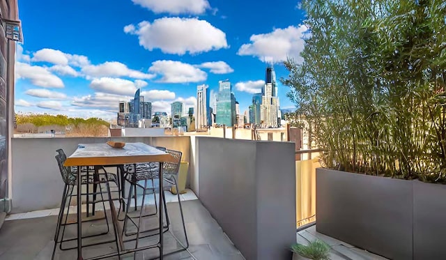 view of patio / terrace with a view of city and a balcony