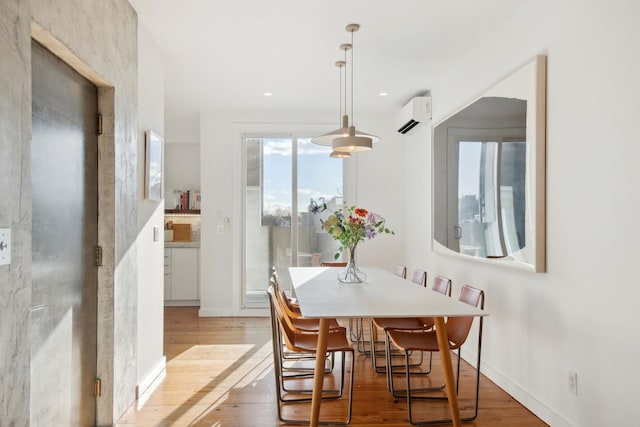 dining room with recessed lighting, baseboards, wood finished floors, and a wall mounted air conditioner