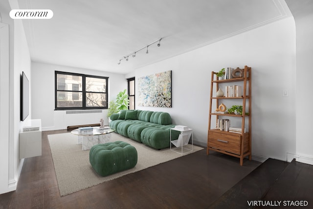 living area with track lighting, visible vents, and wood finished floors