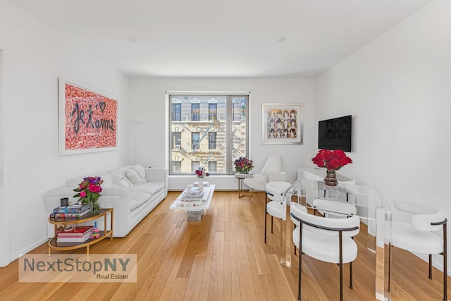 sitting room with baseboards and hardwood / wood-style flooring