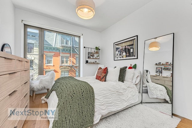 bedroom featuring access to outside and wood finished floors