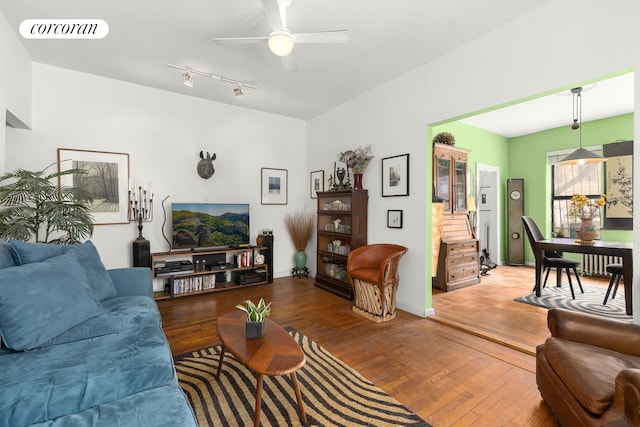 living room with hardwood / wood-style floors, visible vents, and a ceiling fan