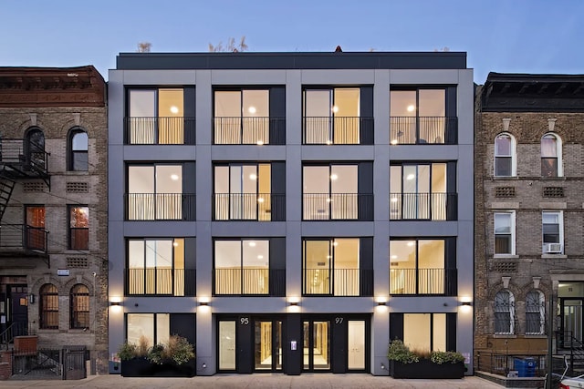 back of property at dusk featuring stucco siding