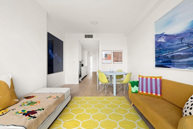 living area featuring light wood-type flooring and visible vents