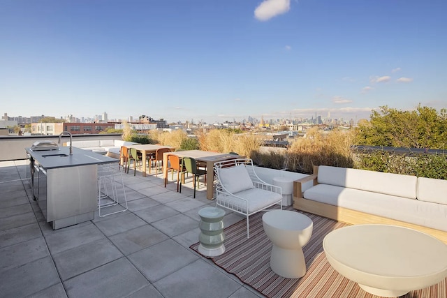 view of patio / terrace with outdoor dining space, outdoor lounge area, a sink, and a city view