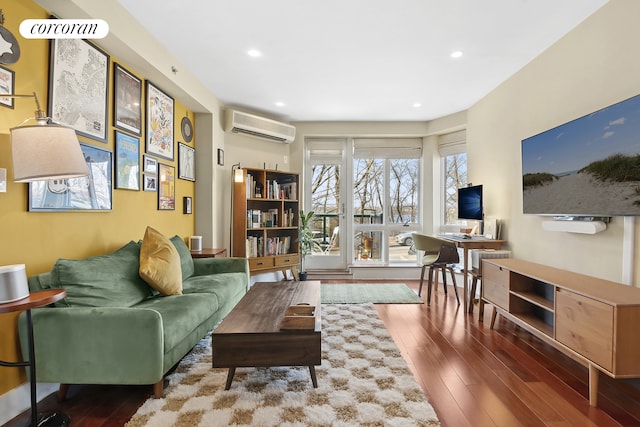 living area with a wall unit AC, recessed lighting, and wood finished floors